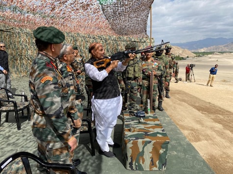 Defence Minister Rajnath Singh tries the Pika Machine Gun while witnessing para dropping and scoping weapons at Stankna near Leh. (Image: RMO India)