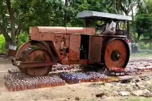 Video grab shows the bottles being crushed by a road roller. (ANI)