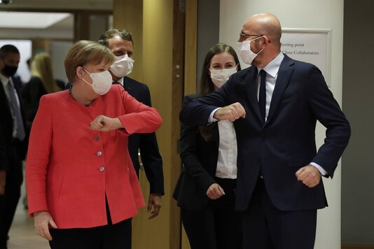European Council President Charles Michel, right, greets German Chancellor Angela Merkel, left, with an elbow bump during a round table meeting at an EU summit in Brussels on Friday. (AP)