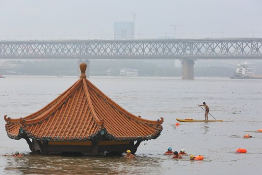 People swim near a pavilion partially submerged in floodwaters on the banks of the Yangtze River, following heavy rainfall in Wuhan, Hubei province, China. (Reuters)
