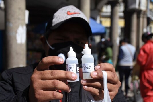 A man shows bottles of chlorine dioxide he purchased at a pharmacy in Cochabamba, Bolivia, Friday, July 17, 2020. Long lines form every morning in Cochabamba, one of the Bolivian cities hardest hit by the new coronavirus pandemic, as people wait to buy small bottles of chlorine dioxide, a toxic bleaching agent that has been falsely touted as a cure for COVID-19 and myriad other diseases. (AP Photo/Dico Solis)


