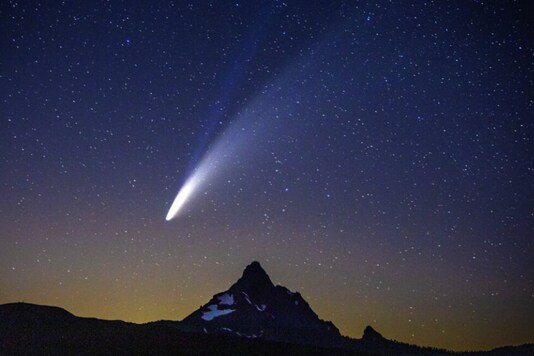 Comet Neowise appears over Mount Washington in the night sky as seen from Dee Wright Observatory on McKenzie Pass east of Springfield on July 14, 2020. According to NASA the lower tail, which appears broad and fuzzy, is the dust tail created when dust lifts off the surface of the comet's nucleus and trails behind the comet in its orbit. The upper tail is the ion tail, which is made up of gases that have been ionized by losing electrons in the sun's intense light. (Chris Pietsch/The Register-Guard via AP)

