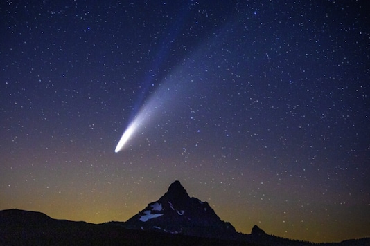 Comet Neowise appears over Mount Washington in the night sky as seen from Dee Wright Observatory on McKenzie Pass east of Springfield on July 14, 2020. According to NASA the lower tail, which appears broad and fuzzy, is the dust tail created when dust lifts off the surface of the comet's nucleus and trails behind the comet in its orbit. The upper tail is the ion tail, which is made up of gases that have been ionized by losing electrons in the sun's intense light. (Chris Pietsch/The Register-Guard via AP)
Comet Neowise appears over Mount Washington in the night sky as seen from Dee Wright Observatory on McKenzie Pass east of Springfield on July 14, 2020. According to NASA the lower tail, which appears broad and fuzzy, is the dust tail created when dust lifts off the surface of the comet's nucleus and trails behind the comet in its orbit. The upper tail is the ion tail, which is made up of gases that have been ionized by losing electrons in the sun's intense light. (Chris Pietsch/The Register-Guard via AP)