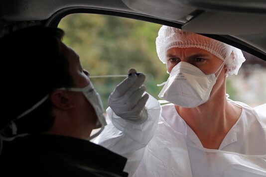 A nurse, wearing protective suit and face mask, administers a nasal swab to a patient at a drive-through testing site for coronavirus disease (COVID-19) near the hospital in Laval, in Mayenne department, France, July 15, 2020. REUTERS/Stephane Mahe A nurse, wearing protective suit and face mask, administers a nasal swab to a patient at a drive-through testing site for coronavirus disease (COVID-19) near the hospital in Laval, in Mayenne department, France, July 15, 2020. REUTERS/Stephane Mahe