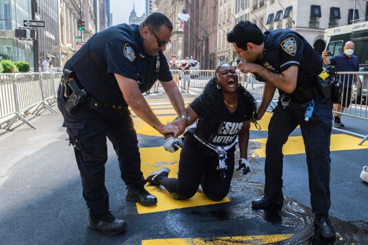 New York Police Department officers attempt to detain a protester who defaced with black paint the Black Lives Matter mural outside of Trump Tower on Fifth Avenue Saturday, July 18, 2020, in the Manhattan borough of New York. (AP Photo/Yuki Iwamura)