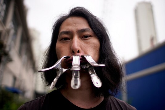 Brother Nut, Chinese performance artist with three metallic clips sealing his mouth, poses for a picture in Shanghai, following the COVID-19 outbreak, China July 13, 2020. Picture taken July 13, 2020. REUTERS/Aly Song
