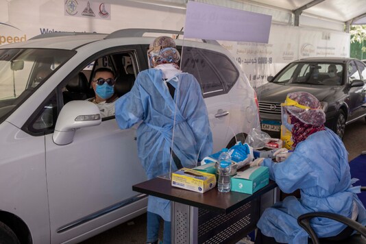 In this file photo, a health worker prepares to take swab samples to test for the coronavirus at a drive-through screening center in Cairo, Egypt. The coronavirus pandemic will exact a heavy toll on Arab countries, causing an economic contraction of 5.7% this year, pushing millions into poverty and compounding the suffering of those affected by armed conflict, a U.N. report said Thursday, July 23, 2020. The U.N.'s Economic and Social Commission for Western Asia expects some Arab economies to shrink by up to 13%, amounting to an overall loss for the region of $152 billion. (AP Photo/Nariman El-Mofty, File)