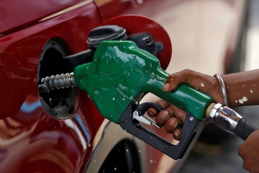 A worker holds a nozzle to pump petrol into a vehicle at a fuel station. (File photo/Reuters)