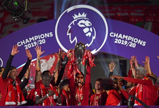 Liverpool's Roberto Firmino holds the English Premier League trophy aloft after it was presented following the Premier League soccer match between Liverpool and Chelsea at Anfield stadium in Liverpool, England, Wednesday, July 22, 2020. (Paul Ellis, Pool via AP)