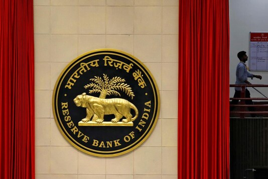 FILE PHOTO: A worker walks past the logo of Reserve Bank of India (RBI) inside its office in New Delhi. REUTERS/Anushree Fadnavis