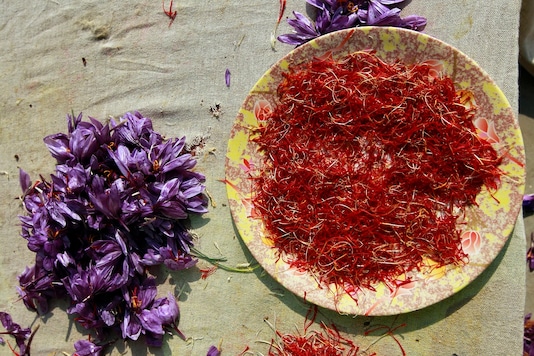 Separated saffron stigmas are kept in a plate beside the flowers during a drying process in Pampore, Kashmir. REUTERS/Fayaz Kabli)