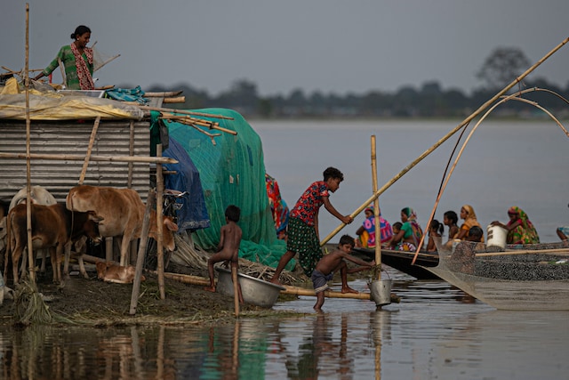 Flood-affected people take shelter at a temporary structure near their submerged house along Brahmaputra river in Morigaon district, Assam, on July 16, 2020. (AP Photo/Anupam Nath)