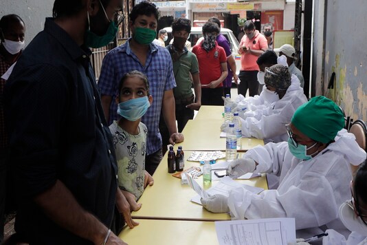 People wait in a queue for swab sample test for COVID-19  at medical camp in Mumbai.  (AP Photo/Rajanish Kakade)