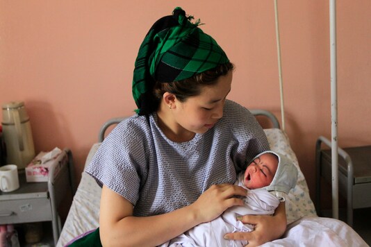 An Afghan woman holds her newborn baby at a hospital in Kabul May 8, 2012. REUTERS/Mohammad Ismail
