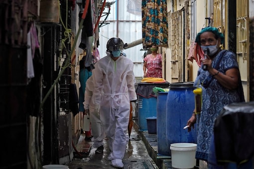 FILE PHOTO: A worker from Bharatiya Jain Sanghatana, a non-governmental organization, walks in an alley to screen the residents during a check-up campaign for  COVID-19 in a slum Mumbai.   (REUTERS/Hemanshi Kamani)