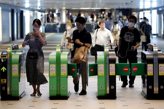 Passengers wearing protective face masks pass through the automated entranceway at a station amid the coronavirus disease (COVID-19) outbreak in Tokyo, Japan July 23, 2020. REUTERS/Issei Kato