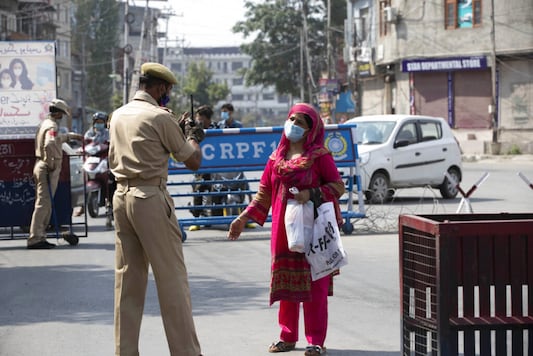 A Kashmiri woman requests a police officer to let her cross a street during curfew in Srinagar, India, Tuesday, Aug. 4, 2020. (AP Photo/Mukhtar Khan) A Kashmiri woman requests a police officer to let her cross a street during curfew in Srinagar, India, Tuesday, Aug. 4, 2020. (AP Photo/Mukhtar Khan)