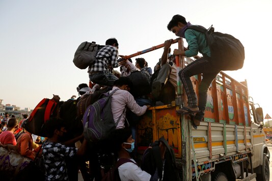 Migrant workers rush to board a tempo that will take them across the border during lockdown. (Reuters File)