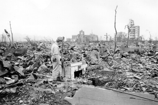 FILE - In this Sept. 7, 1945, file photo, an unidentified man stands next to a tiled fireplace where a house once stood in Hiroshima, western Japan. The Aug. 6, 1945, bombing was the world’s first nuclear attack. An estimated 140,000 people, including those with radiation-related injuries and illnesses, died through Dec. 31, 1945. That was 40% of Hiroshima’s population of 350,000 before the attack. (AP Photo/Stanley Troutman, Pool, File)