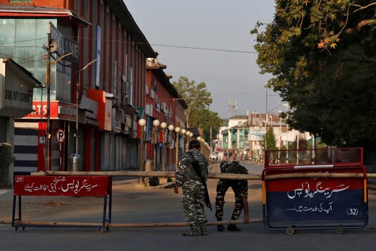 Indian Central Reserve Police Force (CRPF) officers put up a roadblock on an empty street during a lockdown on the first anniversary of the revocation of Kashmir's autonomy, in Srinagar August 5, 2020. REUTERS/Danish Ismail