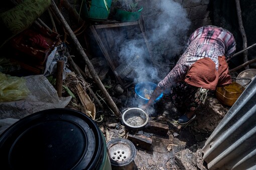 Mother of two Amsale Hailemariam, a domestic worker who lost work because of the coronavirus, prepares food for her family in her small tent in the capital Addis Ababa, Ethiopia on Friday, June 26, 2020. She and her daughter make do with the equivalent of $34 a month that Amsale receives from local authorities for helping with projects like beautifying public spaces and sweeping the streets. But she doesn’t like to go out, fearing infection. (AP Photo/Mulugeta Ayene)