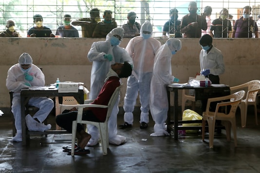 A health worker collects a sample from a man while others await their turn in Mumbai. (Reuters)