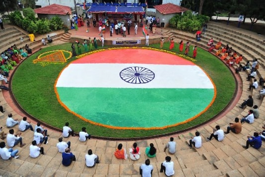 Students and faculty members of a college in Bengaluru sit around a flag drawn in the amphitheatre on the eve of the country's 74th Independence Day. (AFP)
