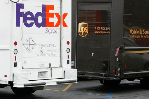 A FedEx truck is parked next to a UPS truck as both drivers make deliveries in downtown San Diego, California March 5, 2013. REUTERS/Mike Blake
