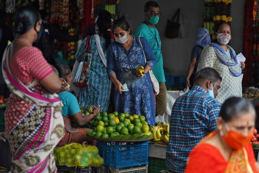 A woman wearing a protective face mask buys fruit in a market, amidst the spread of the coronavirus disease (COVID-19) in Mumbai, India, August 20, 2020. REUTERS/Hemanshi Kamani