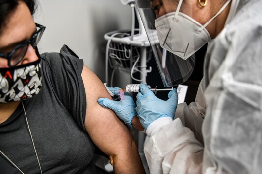 A volunteer receives the Covid-19 vaccine from Yaquelin De La Cruz at the Research Centers of America in Hollywood, Florida on August 13, 2020 (Photo by CHANDAN KHANNA / AFP).