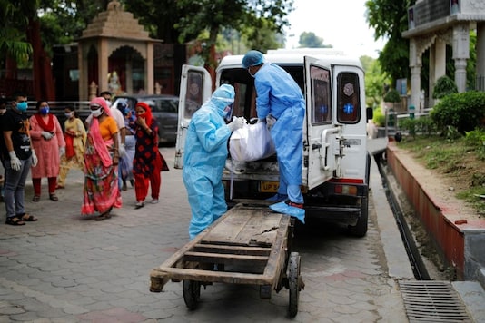 Workers wearing personal protective equipment (PPE) unload a body of a man who died due to the coronavirus disease (COVID-19) before his cremation at a crematorium in New Delhi, India August 22, 2020. REUTERS/Adnan Abidi
