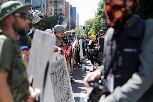 Opposing rallies battle with mace, paint balls and rocks near Justice Center in downtown Portland Saturday, August 22, 2020. (Brooke Herbert/The Oregonian via AP)