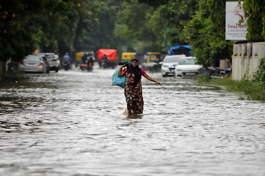 A woman wades through a water-logged road during rains in Ahmedabad. REUTERS/Amit Dave 