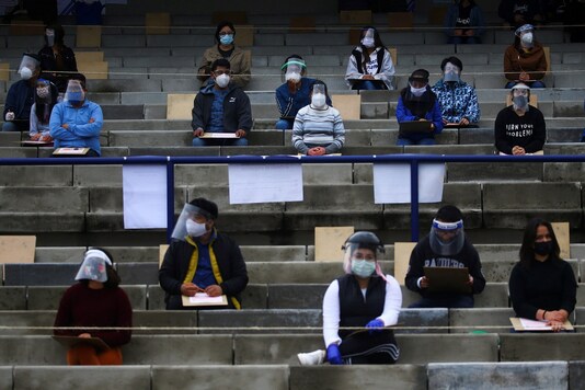 File photo of student in protective face masks maintaining social distancing while appearing for an examination. (Reuters)