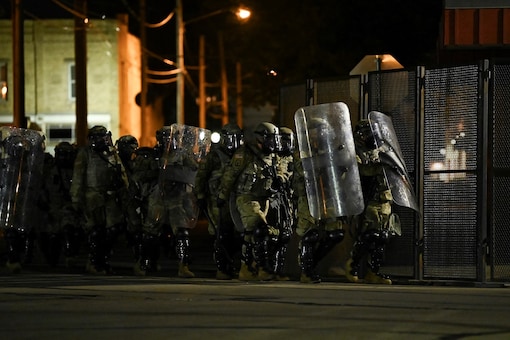 Security forces take position as people protest outside the Kenosha County Courthouse after a Black man, identified as Jacob Blake, was shot several times by police in Kenosha, Wisconsin, U.S. August 25, 2020. REUTERS/Stephen Maturen