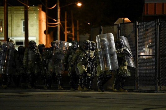 Security forces take position as people protest outside the Kenosha County Courthouse after a Black man, identified as Jacob Blake, was shot several times by police in Kenosha, Wisconsin, U.S. August 25, 2020. REUTERS/Stephen Maturen