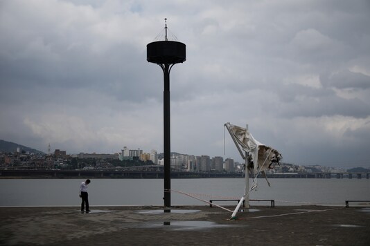 A man wearing a protective face mask walks past a sun shelter damaged by flooded Han river weeks ago, amid the coronavirus disease (COVID-19) pandemic in Seoul, South Korea, August 27, 2020. REUTERS/Kim Hong-Ji