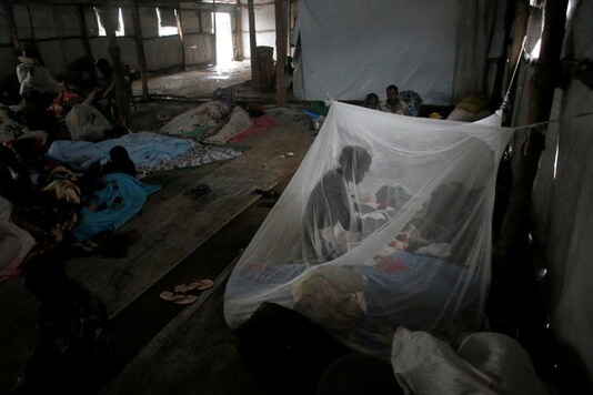 A South Sudanese refugee woman takes care of her baby under a mosquito net in a transit tent at the Imvepi refugee settlement camp in Arua District. Credits: Reuters