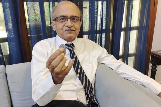 Prashant Bhushan shows a Re 1 coin, the token fine imposed by the SC in the criminal contempt case. Prashant Bhushan shows a Re 1 coin, the token fine imposed by the SC in the criminal contempt case.