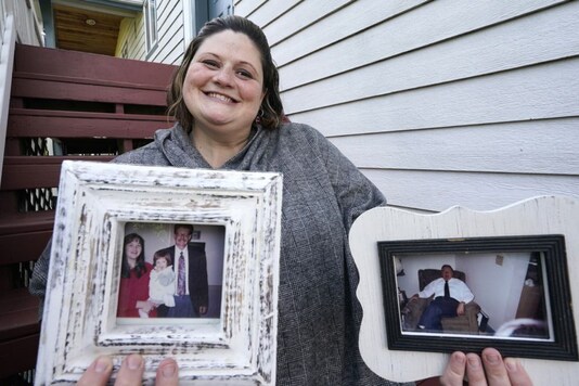Caitlin Joyce holds family portraits, including her as a child with her parents and a photo of her 90-year-old grandfather, at her home on Aug. 29 in Edmonds. Credits: AP