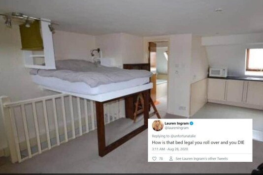 Bed elevated over staircase in UK's studio apartment.