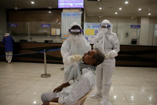 A health worker takes a nasal swab sample to test for COVID-19 at a state bus station in Ahmedabad, India, Saturday, Aug. 29, 2020. (Image: AP)