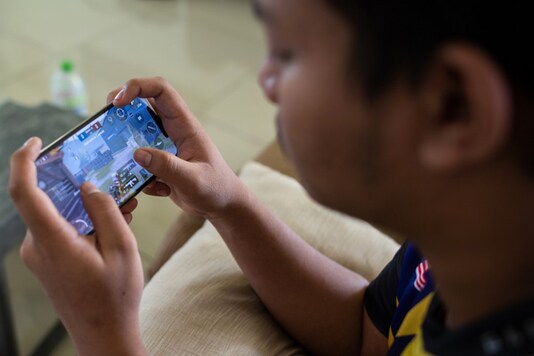This picture taken on August 22, 2020 shows a stateless eSports player playing PlayerUnknown's Battlegrounds (PUBG) on his mobile phone, south of Kuala Lumpur. (AFP)
