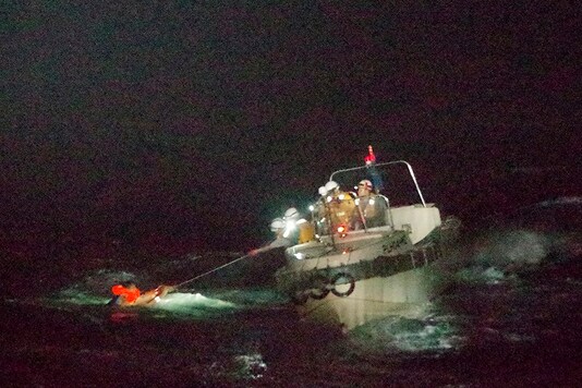 In this photo released by the 10th Regional Japan Coast Guard Headquarters, a Filipino crewmember of a Panamanian cargo ship is rescued by Japanese Coast Guard members on Sept. 2, 2020.  (The 10th Regional Japan Coast Guard Headquarters via AP)
