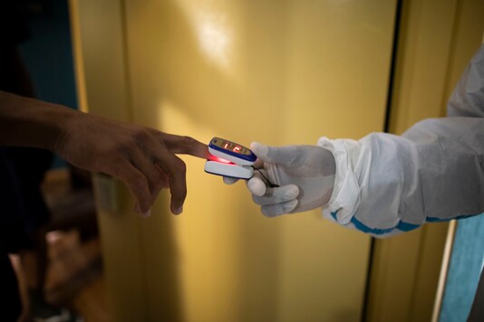 A doctor checks the heart rate and blood oxygenation readings of an asymptomatic COVID-19 patient. (AP/Representational Photo)