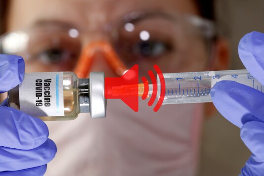 A woman holds a small bottle labeled with a 