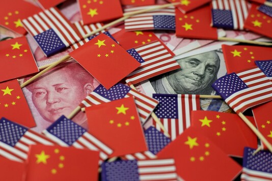 FILE PHOTO: A US dollar banknote featuring American founding father Benjamin Franklin and a China's yuan banknote featuring late Chinese chairman Mao Zedong are seen among U.S. and Chinese flags in this illustration picture taken May 20, 2019. REUTERS/Jason Lee/Illustration/File Photo