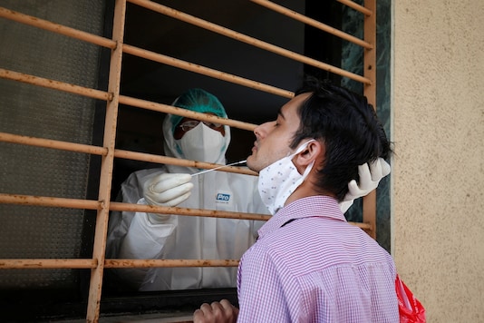 A healthcare worker wearing personal protective equipment (PPE) takes swab from a man for a rapid antigen test, amidst the coronavirus disease (COVID-19) outbreak, in Ahmedabad. (Reuters)