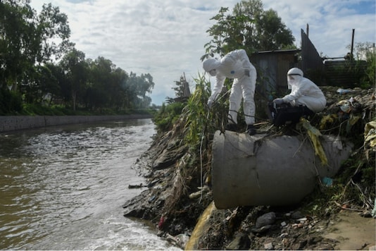 Researchers in Nepal collect samples of sewage dumped into a river to trace the spread of the coronavirus. Credits: AFP