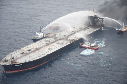 A Sri Lankan Navy boat sprays water on the New Diamond, a very large crude carrier (VLCC) chartered by Indian Oil Corp (IOC), that was carrying the equivalent of about 2 million barrels of oil, after a fire broke out off east coast of Sri Lanka September 8, 2020. Sri Lankan Airforce media/Handout via REUTERS
